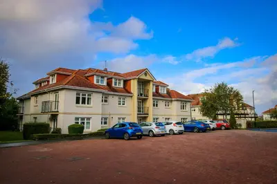 a row of cars parked in front of a house at Turnberry Apartments in Turnberry