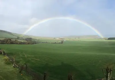a rainbow in a field with a green field at Carrick Hills Cosy Croft STL SA-00137-F in Dunure