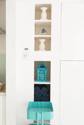 a blue stool in front of a shelf with vases at The Retreat Studio in Carlisle