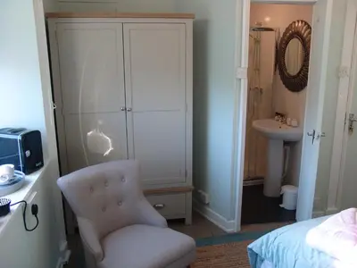 a bedroom with a chair and a bed and a sink at Osborne House B&B Workington in Workington