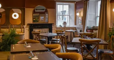 a restaurant with tables and chairs and a fireplace at Royal Oak at Keswick in Keswick