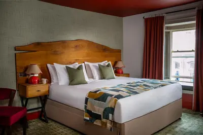 a hotel room with a large bed and a window at Royal Oak at Keswick in Keswick