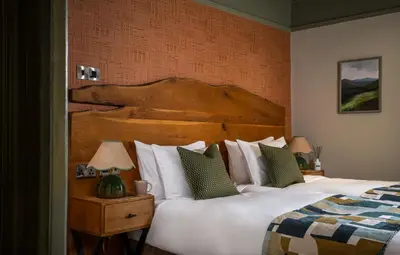a bedroom with a large bed with a wooden headboard at Royal Oak at Keswick in Keswick