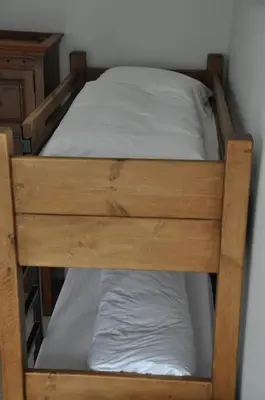 a wooden bunk bed with white sheets at Rooms36 in Keswick
