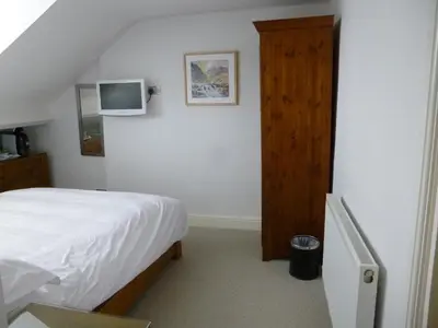a bedroom with a bed and a tv on the wall at Rooms36 in Keswick