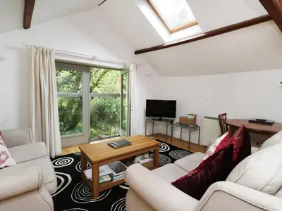 a living room with two couches and a table at Holemire Barn in Cockermouth