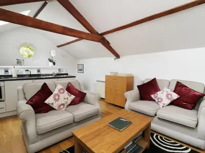 a living room with two couches and a table at Holemire Barn in Cockermouth