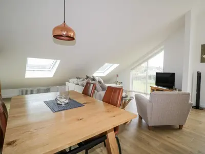 a living room with a wooden table and a couch at Coney Garth Retreat in Beckermet