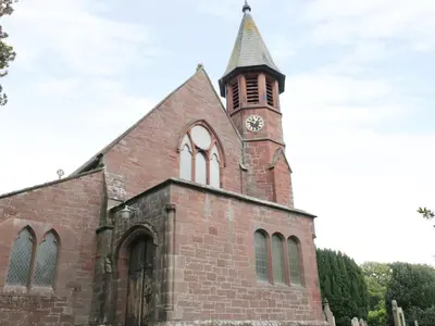 a church with a clock tower on top of it at Coney Garth Retreat in Beckermet