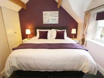 a bedroom with a large bed with purple walls at Shepherd's Crook in Ambleside