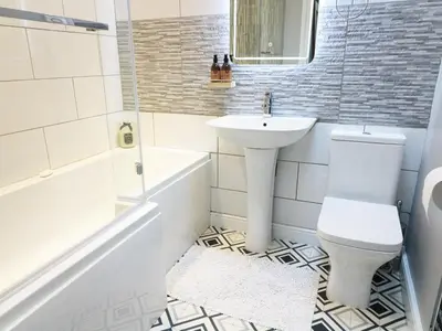a white bathroom with a sink and a toilet at Shepherd's Crook in Ambleside
