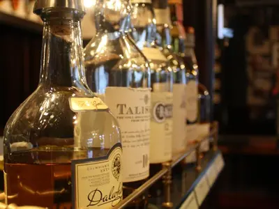 a row of bottles of alcohol on a shelf at The Bladnoch Inn in Bladnoch