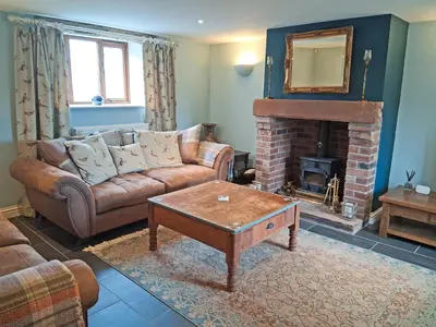 a living room with a couch and a fireplace at Swallow Barn in Torpenhow