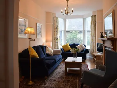 a living room with blue couches and yellow pillows at Otterbield in Keswick