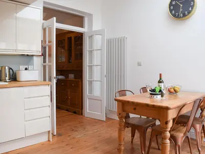 a kitchen with a wooden table and a clock on the wall at Otterbield in Keswick