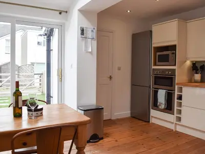 a kitchen with a wooden table and a refrigerator at Otterbield in Keswick