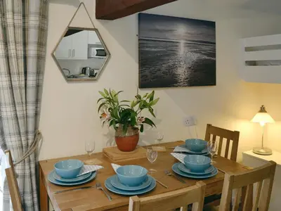 a dining room table with blue dishes on it at Barn Owl Bothy in Westward