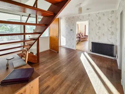 a living room with a wooden staircase in a house at Gullsway in Glencaple