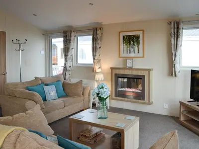 a living room with a couch and a fireplace at Beachcomber Lodge in Mainsriddle