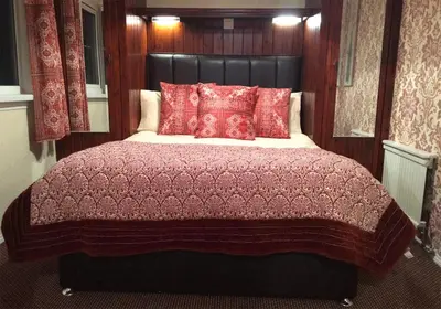 a bedroom with a large bed with red pillows at Limestone Lodges in Bothel