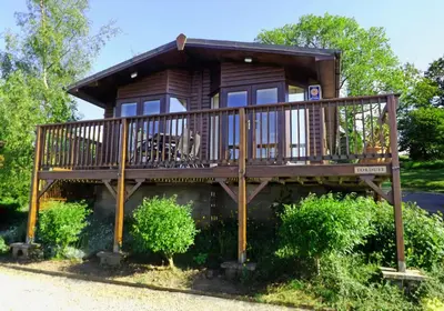 a tree house with a porch and a deck at Limestone Lodges in Bothel