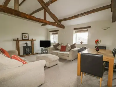 a living room with two couches and a table at Carleton Mill Cottage in Carlisle