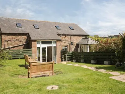 a brick house with a bench in the yard at Swallows Nest in Carlisle