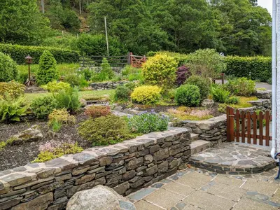 a garden with a stone wall and some plants at The Haven in Keswick