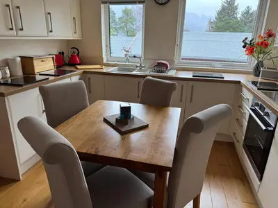 a kitchen with a wooden table and chairs and a sink at The Haven in Keswick