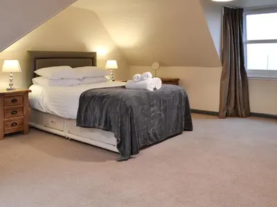a bedroom with a bed with two towels on it at Liftingstane Farmhouse in Closeburn