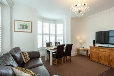 a living room with a couch and a table at Carlton 2 a large modern Keswick appt with parking in Keswick