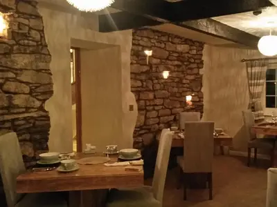 a dining room with a wooden table and a stone wall at Littlebeck Warren in Whitehaven