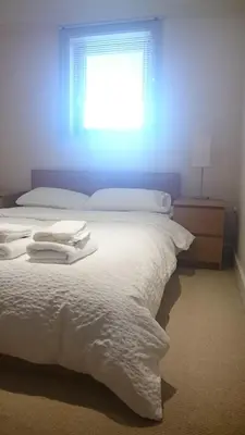 a bedroom with a white bed with a window at Harbourside Apartment in Whitehaven