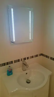 a bathroom with a white sink and a mirror at Harbourside Apartment in Whitehaven