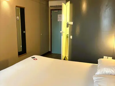 a bedroom with a white bed and a mirror at ibis Carlisle City Centre in Carlisle
