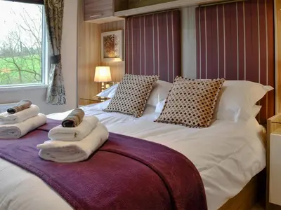 a bedroom with a large bed with towels on it at Skylark Lodge in Westward