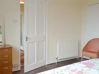 a bedroom with a white closet door and a bed at Beuchan Bungalow in Closeburn