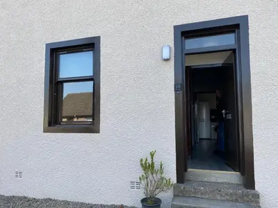 a person walking into a door of a building at Welltrees Apartments 10 Dailly Road in Maybole