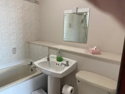 a bathroom with a sink and a toilet and a mirror at Welltrees Apartments 8 Dailly Road in Maybole