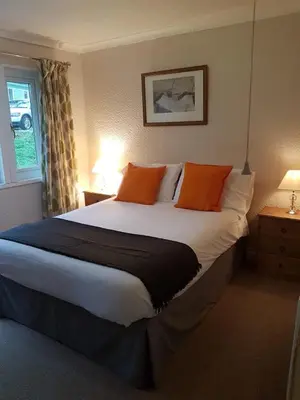 a bedroom with a large bed with orange pillows at Parkgate Farm in Holmrook