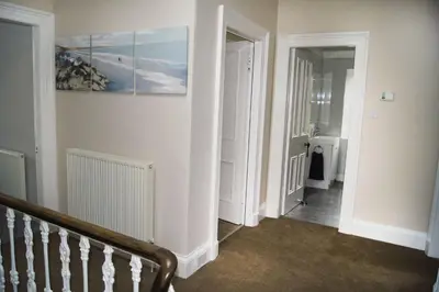 a hallway with a staircase and a painting on the wall at Ayr Beach View Apartment in Ayr