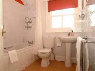 a white bathroom with a toilet and a sink at Craglands Guest House in Keswick