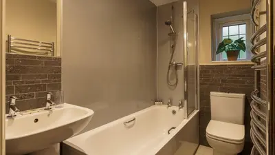 a bathroom with a tub and a sink and a toilet at The Mary Mount Hotel in Keswick