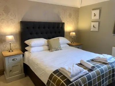 a bedroom with a large bed with two tables and two lamps at The Mary Mount Hotel in Keswick