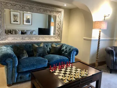 a living room with a blue couch and a chessboard at The Mary Mount Hotel in Keswick