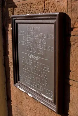 a plaque on the side of a building at The Fairburn Hotel in Mauchline