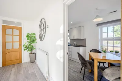 a kitchen and a dining room with a table and a door at Cosy Apartment in Wetheral,Cumbria in Wetheral