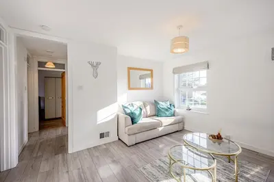 a living room with a couch and a glass table at Cosy Apartment in Wetheral,Cumbria in Wetheral