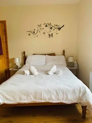 a large white bed with two pillows on it at Private Apartment in Dumfries