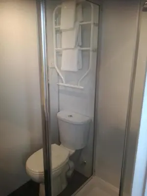 a small bathroom with a toilet and a shower at Allerdale Guest House in Keswick